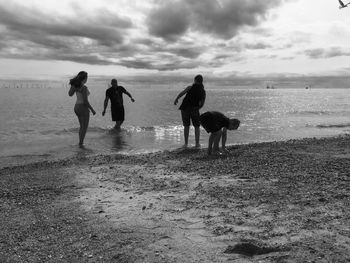 People walking on beach against sky