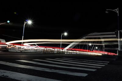 Light trails on road against sky at night