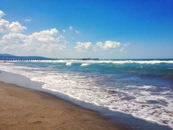 Scenic view of beach against blue sky