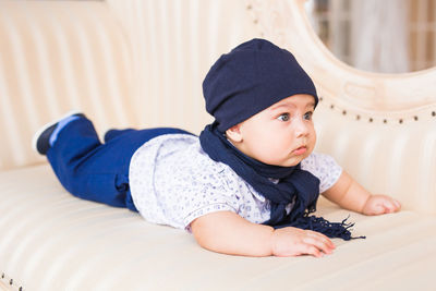 Cute boy looking away while relaxing at home