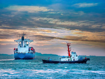 Ship sailing on sea against sky during sunset