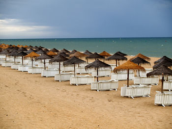 Line of umbrellas and sunbeds without people on the beach