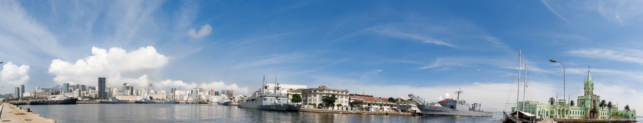 Panoramic view of buildings and harbor against blue sky