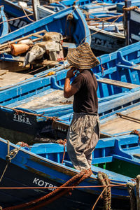 Rear view of man working in boat