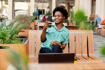 A young african girl with glasses takes a selfie photo on her smartphone