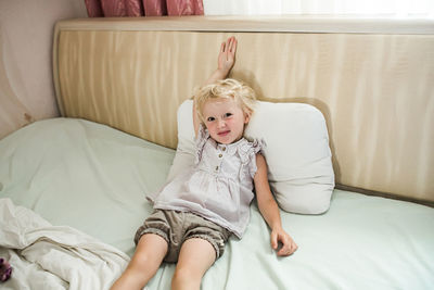 Portrait of woman sitting on bed at home