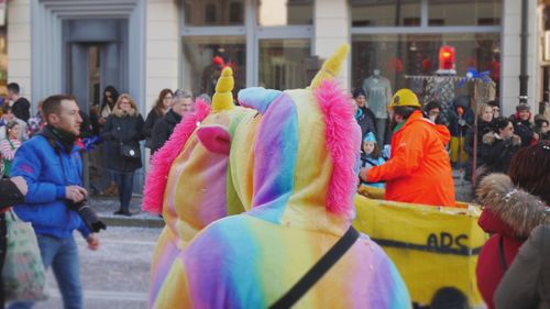 People wearing costumes on street in city during carnival