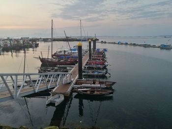 Fishing boats in sea at sunset