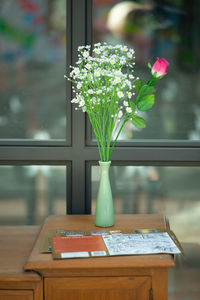 Close-up of flower vase on table by window