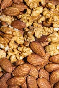 Peeled almond seeds and walnuts, close up background.