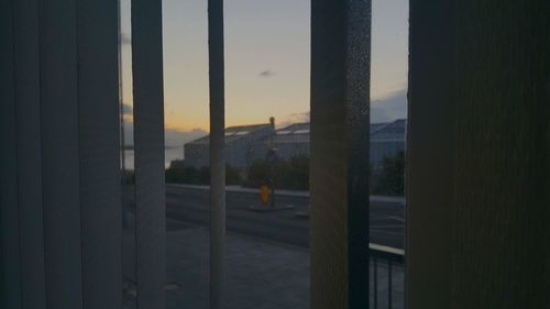 Buildings seen through window during sunset