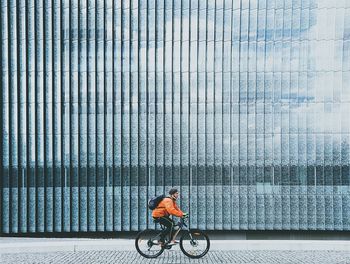 Man cycling on bicycle against sky