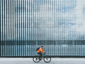 Man cycling on bicycle against sky