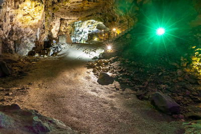 Illuminated rock formation in water at night