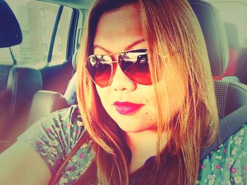 Woman wearing sunglasses in car