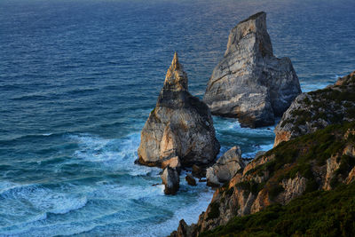 Rock formation in sea against sky