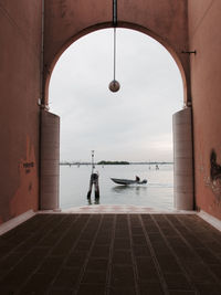 Motorboat sailing on grand canal seen through arch