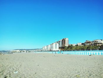 View of beach against clear blue sky