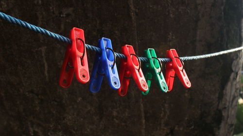 Close-up of multi colored clothespins hanging on rope