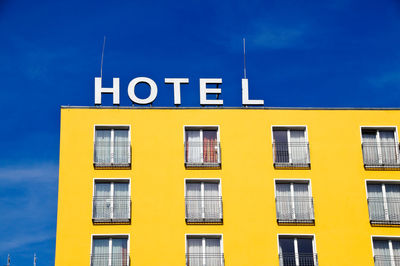 Close-up of yellow building against blue sky