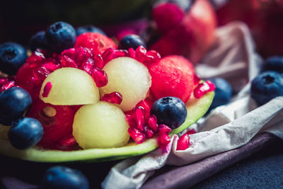Composition of fresh fruit. fruit salad with pomegranate, melon, watermelon and blueberries. 