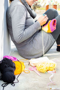 Midsection of woman holding umbrella while sitting in winter
