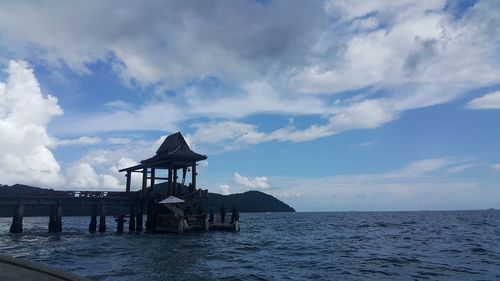 Built structure on pier by sea against sky