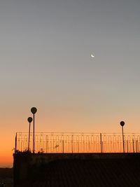 Street lights against orange sky