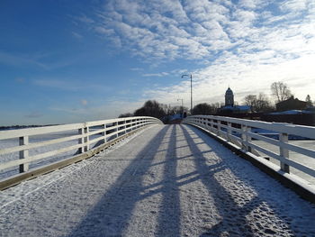 Road by bridge against sky