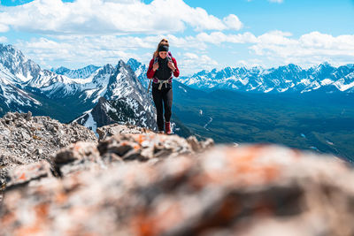 Hiker walking along mountain summit in kananaskis country