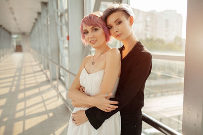 Portrait of young lesbians embracing at corridor in building