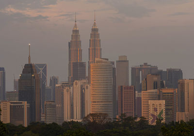 Skyscrapers in city against cloudy sky