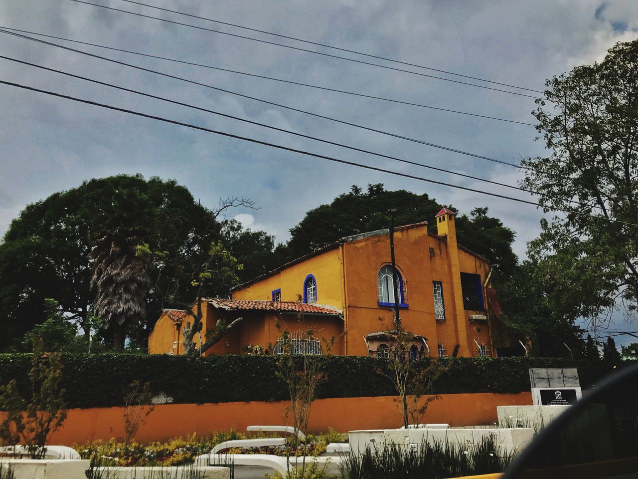 tree, sky, cable, plant, mode of transportation, architecture, transportation, nature, built structure, land vehicle, building exterior, motor vehicle, power line, connection, car, no people, electricity, low angle view, building, day, outdoors, telephone line, power supply