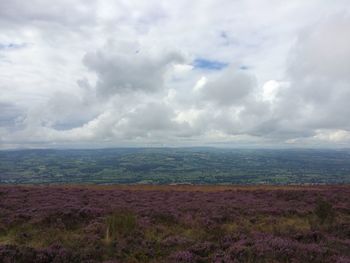 View of fields against cloudy sky