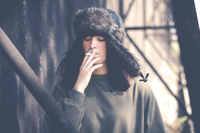 Close-up of young woman smoking on snow