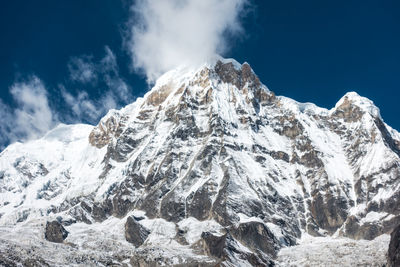 Low angle view of snowcapped mountains against sky