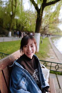 Portrait of smiling woman sitting on bench