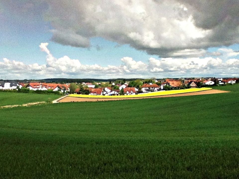 grass, field, sky, landscape, cloud - sky, green color, agriculture, rural scene, grassy, large group of people, farm, cloudy, cloud, nature, beauty in nature, tranquil scene, scenics, tranquility, built structure, architecture