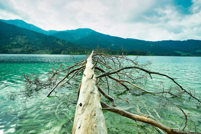 Scenic view of lake by mountains against sky