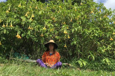 Portrait of man wearing hat sitting on field