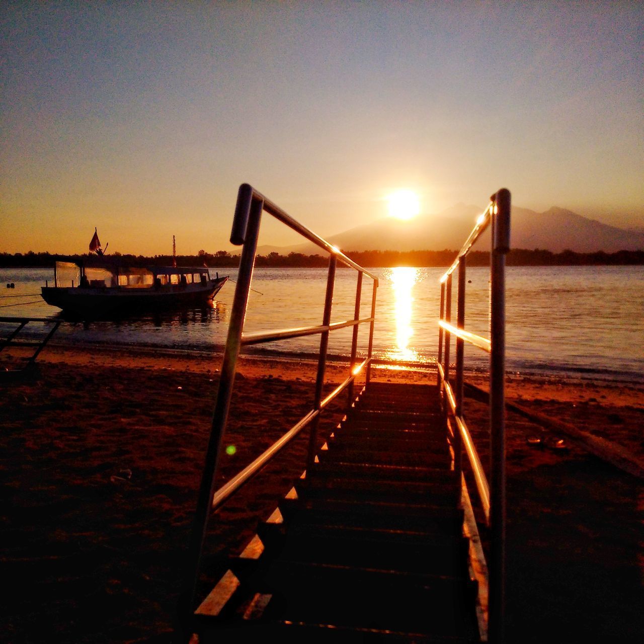 PIER OVER SEA AGAINST ORANGE SKY