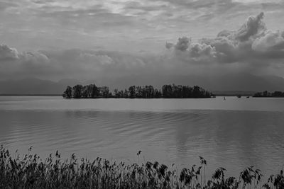 Scenic view of lake chiemsee and krautinsel  against dramatic sky