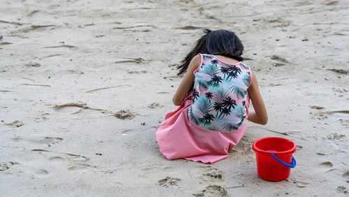 Rear view of girl walking on sand