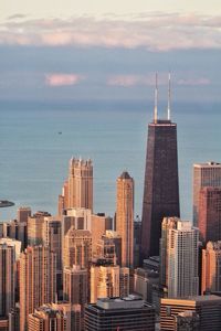 Cityscape by lake michigan against sky