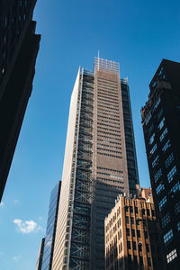 Low angle view of modern buildings against clear blue sky