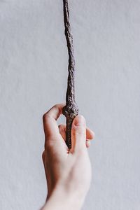 Close-up of hand holding paper against white background