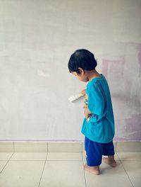 Full length of boy painting wall at home