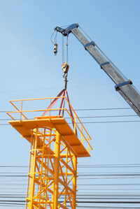 Low angle view of crane against clear sky