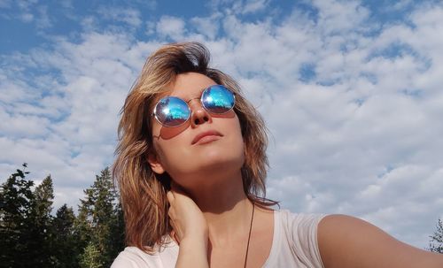 Portrait of woman wearing sunglasses against sky