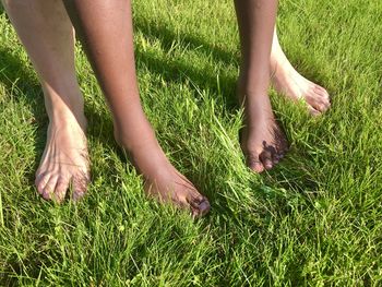 Low section of man and child on grass in field